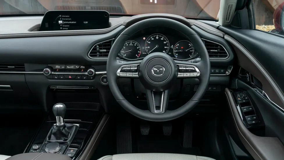 Mazda CX‑30 interior con pantalla y volante, tecnología embarcada
